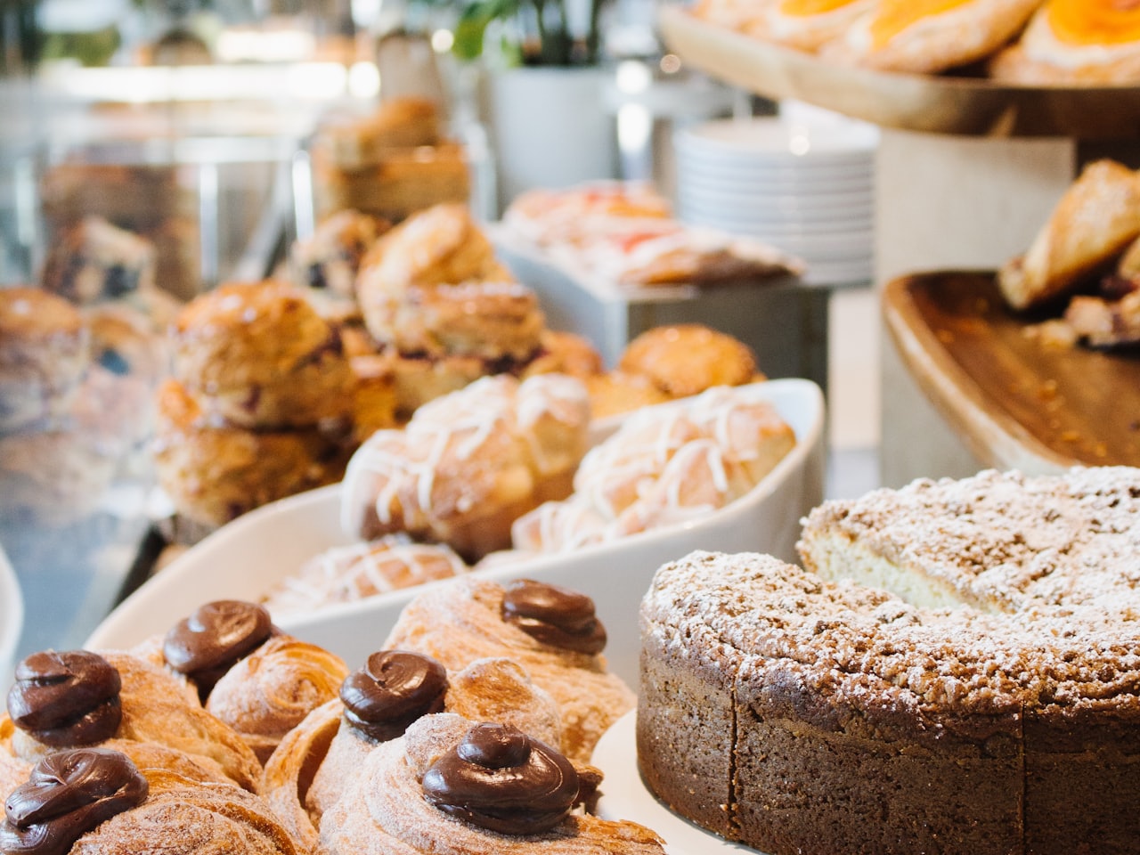 A counter of freshly baked sourdough loaves, croissants and a layered celebration cake at Crumb and Co.